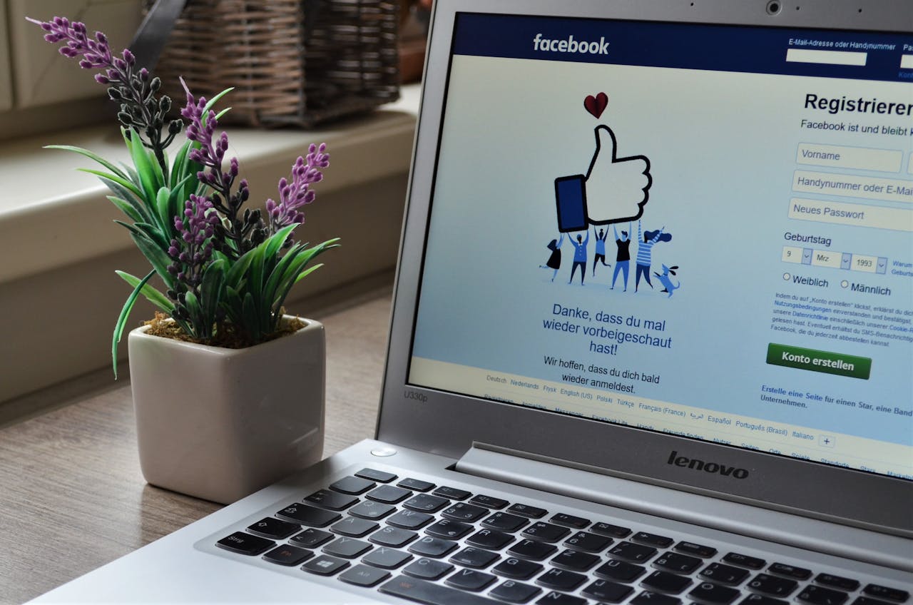 services-03 A Lenovo laptop displaying Facebook login beside a lavender plant indoors.